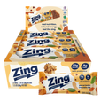 A display box and individual wrapped Zing Energy Bar snack bars on a plain white background. The packaging features orange, white, and blue colors with illustrations of almonds, chocolate pieces, and green leaves, and text indicating peanut butter chocolate chip flavor.