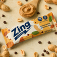 Zing energy bar with peanuts and chocolate chips on a beige background