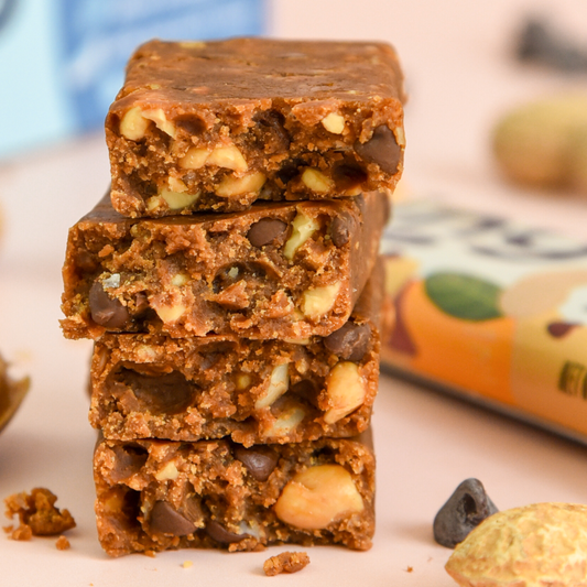 Stack of chocolate chip cookie dough bars with a blurred package in the background